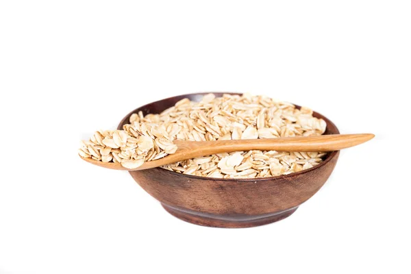 Wooden bowl with oats flakes pile on white background. — Stock Photo, Image