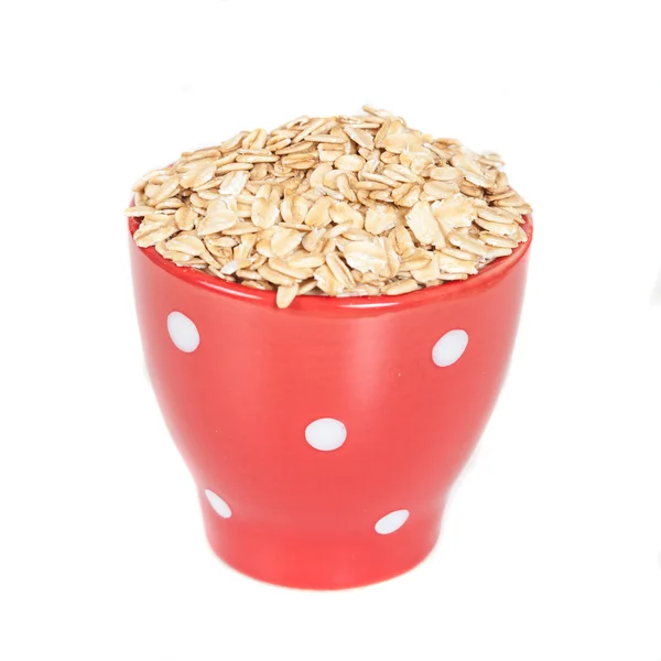 Kırmızı cup yulaf gevreği ile beyaz arka plan üzerinde kazık.