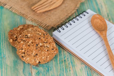 bütün tahıl çerez ile not defteri üzerinde ahşap tablo