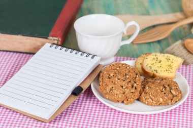 bütün tahıl çerez ile not defteri üzerinde ahşap tablo
