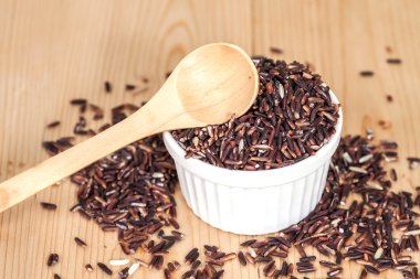 Ahşap arka plan üzerinde kasede pirinç berry