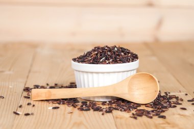 Ahşap arka plan üzerinde kasede pirinç berry