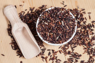 Ahşap arka plan üzerinde kasede pirinç berry