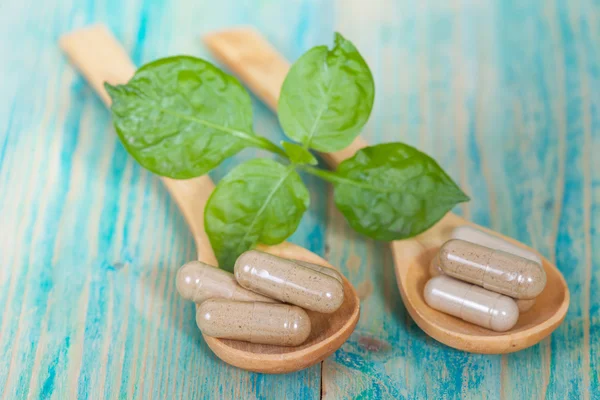 Capsules of herbs on spoon. healthy eating for healthy living. — Stock Photo, Image