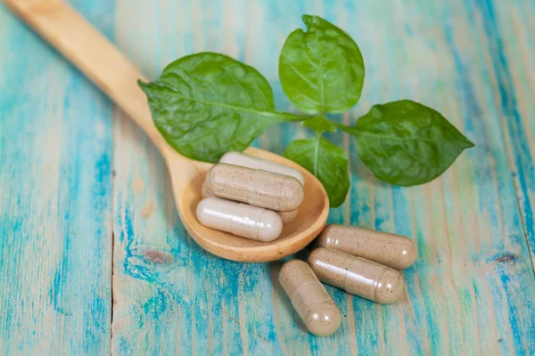 Capsules of herbs on spoon. healthy eating for healthy living. — Stock Photo, Image