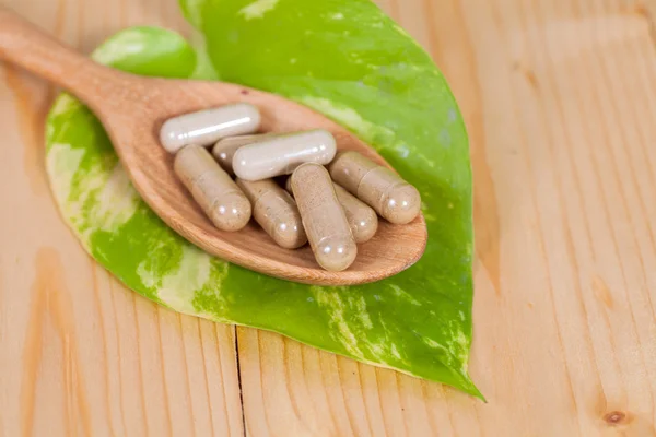 Capsules of herbs on spoon. healthy eating for healthy living. — Stock Photo, Image