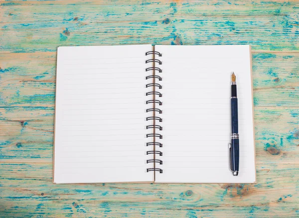 Fehér notebook és a toll a fa tábla — Stock Fotó