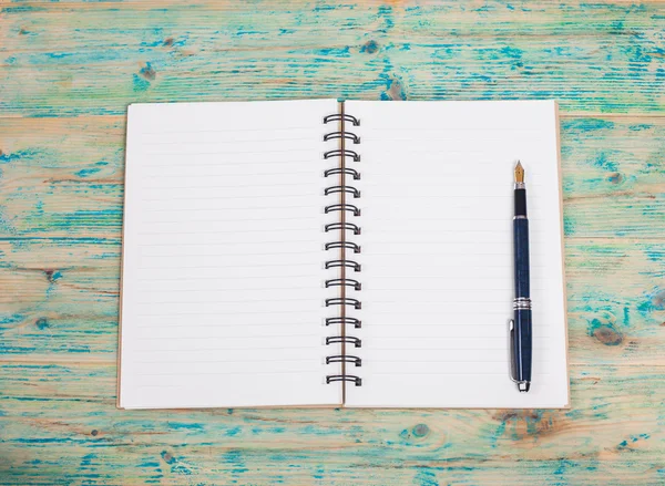 Cuaderno blanco y pluma sobre mesa de madera —  Fotos de Stock