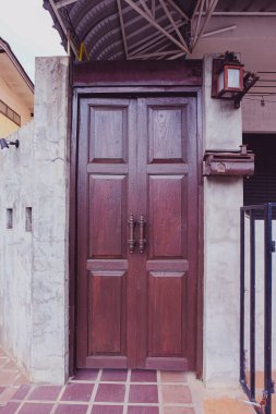 Eski kırmızı ahşap kapı grunge beton duvarda.