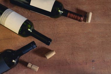 Boş yeşil şarap şişesi grunge ahşap masa arkasında.