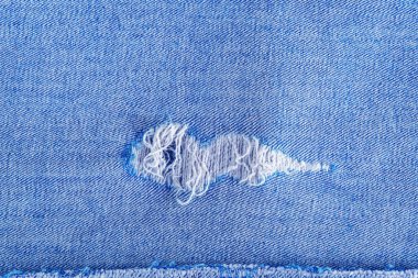 Kot desenli yırtık. Delik ve iplikleri gösteriyor..