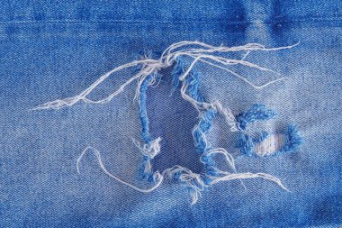 Kot desenli yırtık. Delik ve iplikleri gösteriyor..