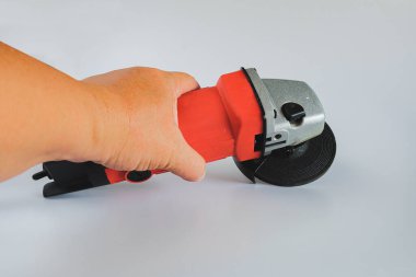 Arkaplanda aşındırıcı diski olan güçlü açı öğütücü.