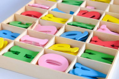 Tahta kutudaki çocukların dekorasyonu için farklı renklerde harfler..