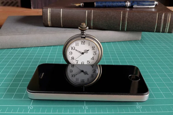 带手机和商业工具的老式怀表放在桌上 — 图库照片