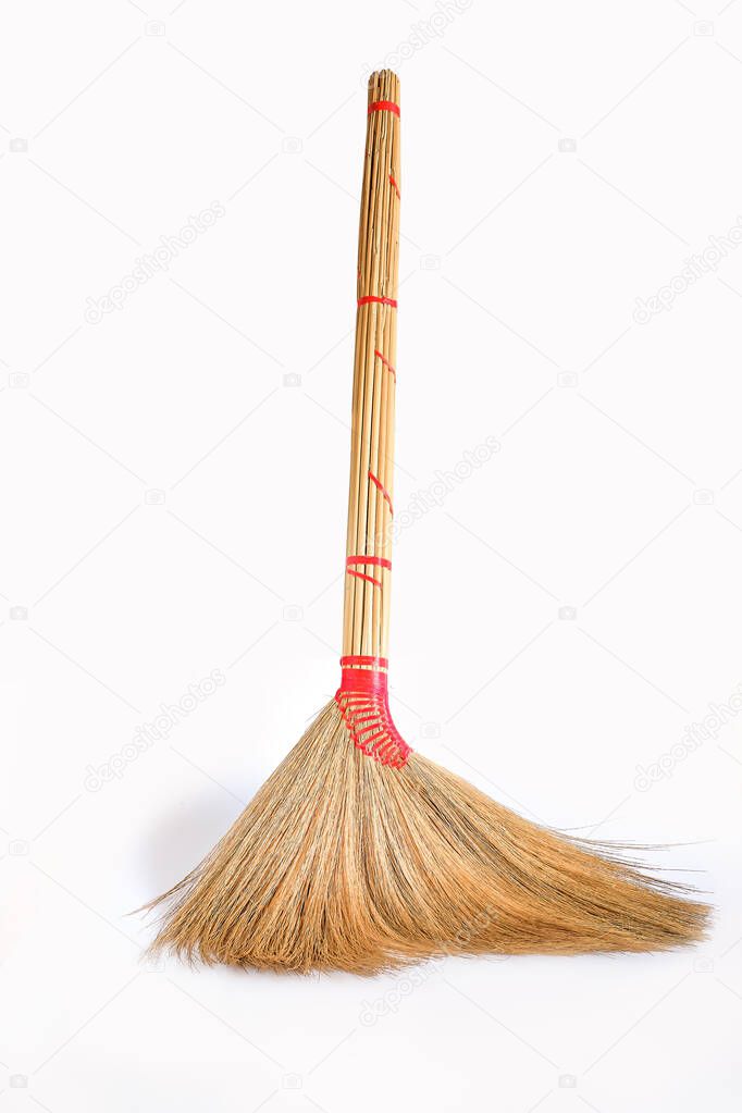 Big yellow broom sweep floor with long wooden handle.