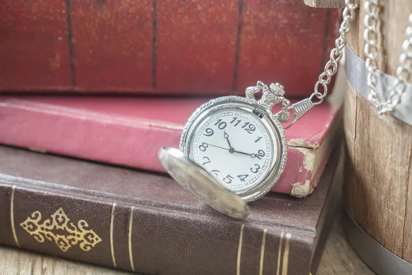 Pocket clock over old books — Stock Photo, Image