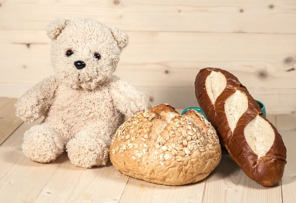 Miś zabawka z chlebem na drewno — Zdjęcie stockowe