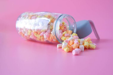 Arka planda renkli şeker şişesi.