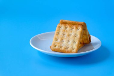 Crispy crackers or biscuits in white dish .