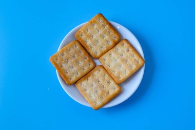 Crispy crackers or biscuits in white dish .
