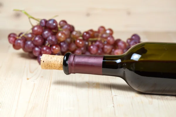 Bottle of  wine and grape  on wooden table — Stock Photo, Image