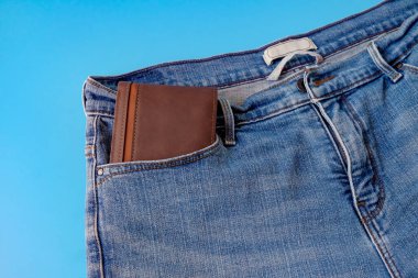 Kot pantolonun cebinde kahverengi bir cep harçlığı. Mali işler.