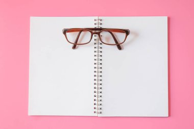 Pembe arka planda gözlük.