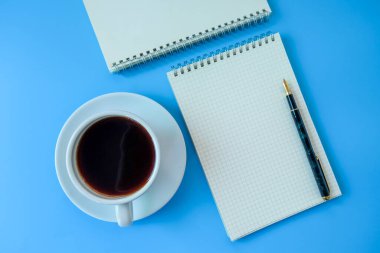 Mavi arka planda boş kitap notu olan sade kahve..