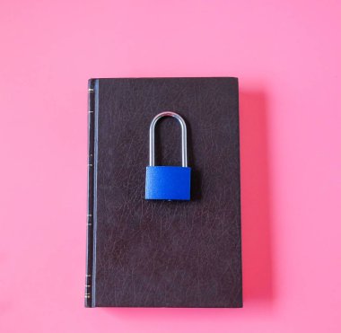 Arka planda deri bir kitap olan bir kilit..