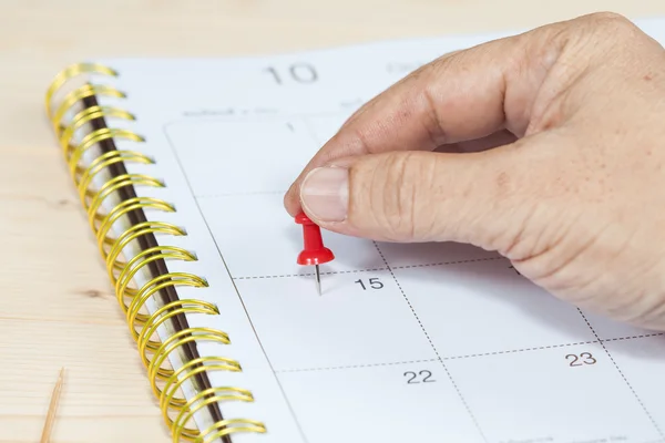 Hand duwen een pin mark op kalender — Stockfoto