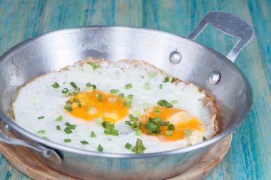 Ahşap masa üzerinde tavada yumurta 