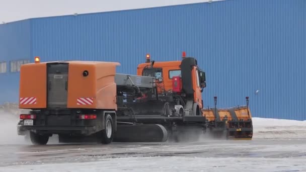Riesige Schneefräsen räumen den Asphalt frei. Eine große orangefarbene Maschine entfernt Schnee. — Stockvideo