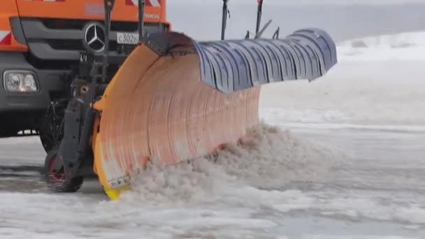 Hatalmas hófúvó megtisztítja az aszfaltot. Egy nagy narancssárga gép eltávolítja a havat. Közelről. — Stock videók