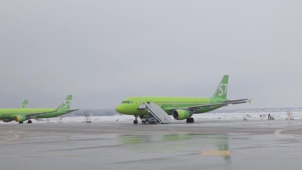 Dolly disparando aviones en el aeropuerto. Aviones verdes de la aerolínea rusa S7 — Vídeos de Stock