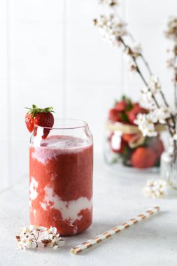 Beyaz arka planda çiçekli çilekli smoothie.