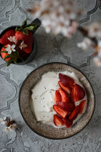 Jogurt s jahodami a květinami — Stock fotografie