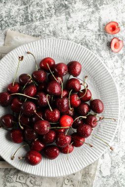 Gri arkaplanda su sıçramış kiraz.