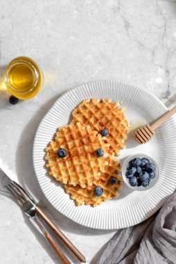 Hafif arkaplanda yaban mersinli ve ballı waffle. Yüksek kalite fotoğraf