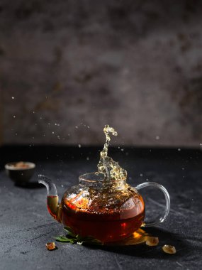 Koyu arkaplanda çay olan şeffaf çaydanlık. Yüksek kalite fotoğraf