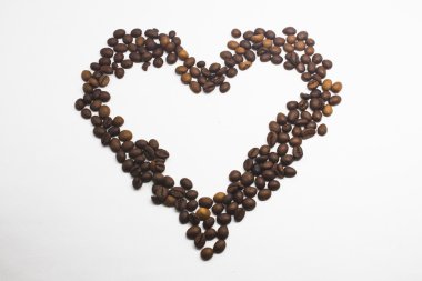 Kalp şeklinde kahve çekirdekleri beyaz arka planda izole..
