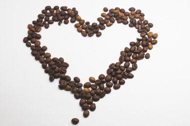 Kalp şeklinde kahve çekirdekleri beyaz arka planda izole..