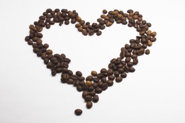 Kalp şeklinde kahve çekirdekleri beyaz arka planda izole..
