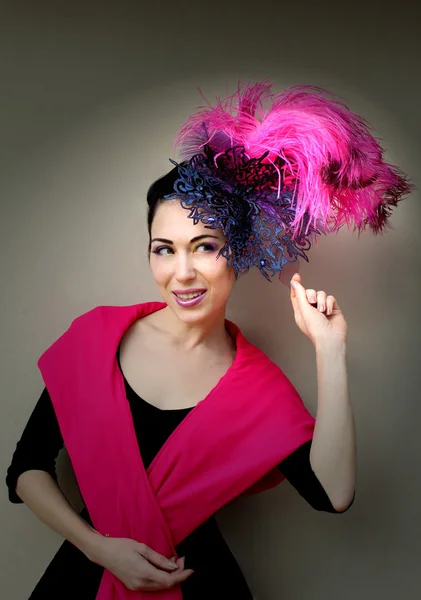 Beautiful young woman in lace lilac purple hat fascinator with feathers on grey background. — Stock Photo, Image