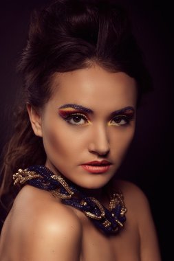 Kahverengi gözlü kadın moda portre. Altın takı. Turuncu öldürülecek