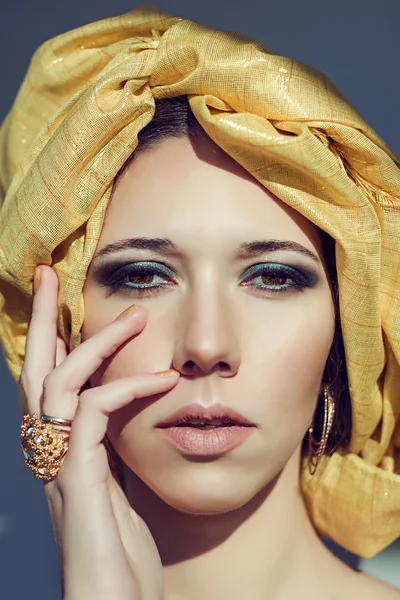 Chica árabe con turbante. Joyas de oro. Maquillaje ojos turquesa ahumado . — Foto de Stock