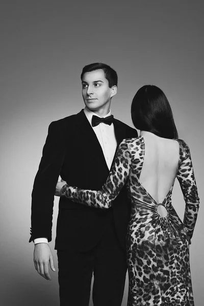 Giovane coppia di modelle uomo e donna vestita con eleganti abiti da sera di tendenza classica: abito, papillon e lungo abito leopardato stampa animalier. lusso. Sessualità. Sensualità. Sensazioni ed emozioni . — Foto Stock