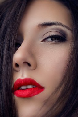 Yakın çekim mükemmel açık cilt esmer genç cinsel güzel gizemli kadın portresi. Moda makyaj hafif dumanlı gözler, oklar ve saç modeli düz uzun saç. Şehvetli kırmızı dudaklar. Modeli atış.