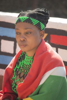 South Africa, Gauteng, Lesedi Cultural Village (unique center of African culture) - 04 July, 2015 . Portrait of young beautiful Sesotho woman Bantu nation in traditional ethnic handmade beads clothes, accessories and colourful blanket. clipart
