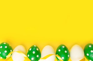 Sarı arka planda Paskalya yumurtası. Paskalya yumurtaları sarı arka planda çerçevelenir. Mutlu Paskalyalar. Üst görünüm, düz görünüm.